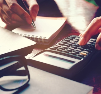Person using a calculator and a notepad.