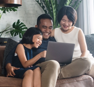 A couple looking at a computer with their daughter